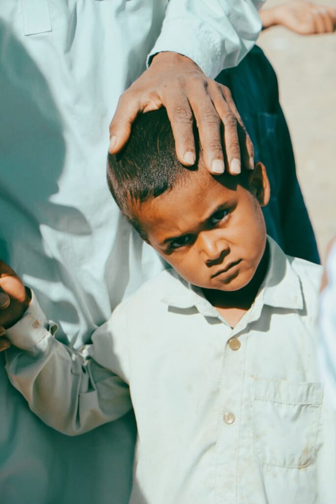 Young boy holding his head after a fall, relevant to skull fracture in children symptoms
