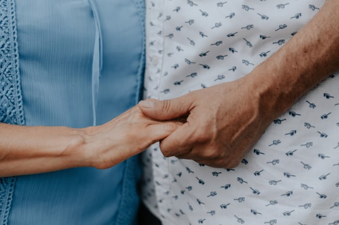 Family member holding hands with a patient, supporting traumatic brain injury recovery at home