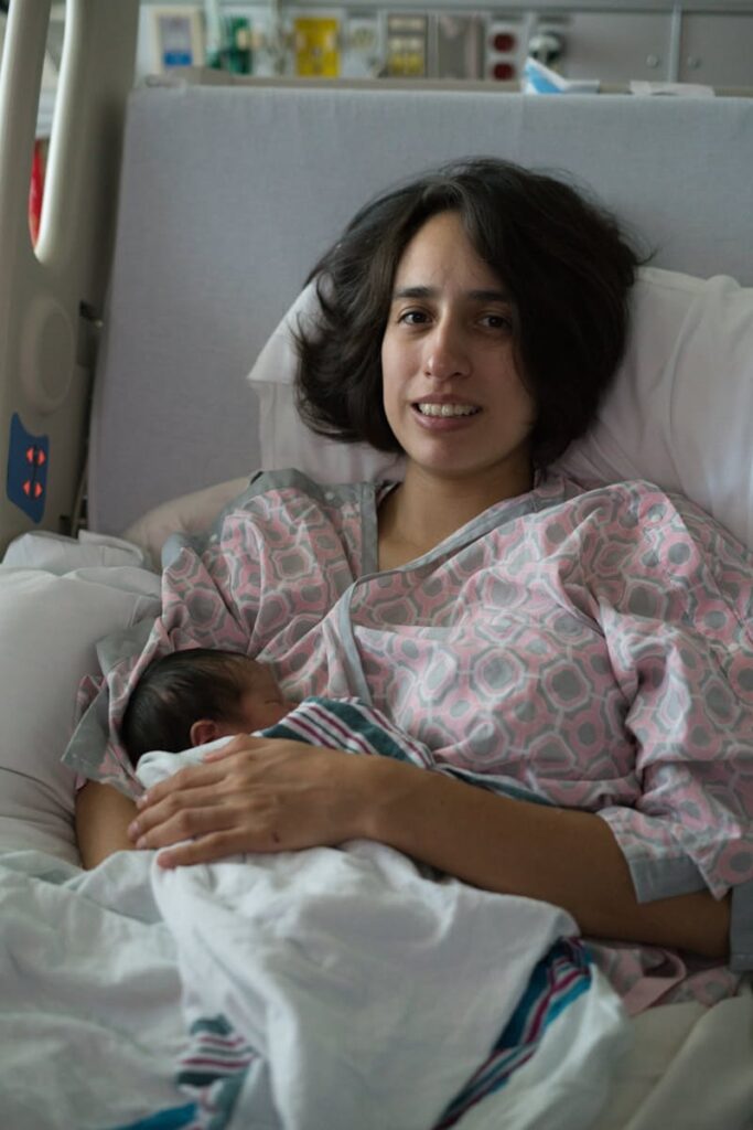 Mother holding her newborn baby in a hospital bed, relevant to pediatric hydrocephalus and VP shunt treatment discussed in this guide
