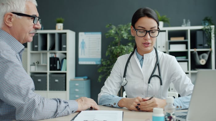 Doctor consulting a patient, deciding between a neurologist in Faisalabad and a neurosurgeon